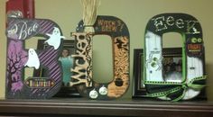 three wooden letters decorated with halloween decorations on top of a shelf in front of a wall