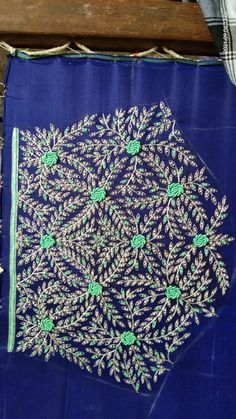 a piece of blue cloth with white and green flowers on it sitting on a wooden table