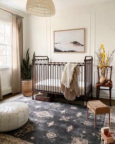 a baby crib in the corner of a room with a large rug on the floor