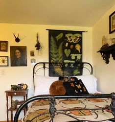 a bed in a room with pictures on the wall above it and an iron frame