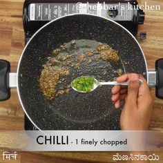 someone is stirring food in a wok on the stove top with a spoon to stir it