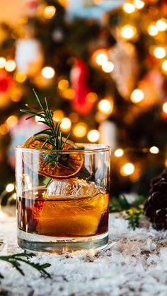 an old fashioned cocktail in front of a christmas tree