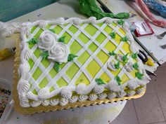 a cake that is sitting on top of a table next to scissors and paintbrushes