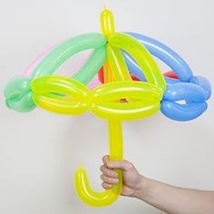 a hand holding an umbrella made out of balloons