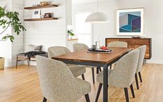 a dining room table and chairs in front of a wall with white shiping on it