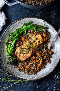 two plates with salmon, lentils and broccoli on them