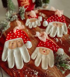 christmas decorations made to look like santas gloves on a wooden platter with pine branches