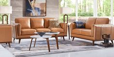 a living room filled with brown furniture and pillows on top of a carpeted floor