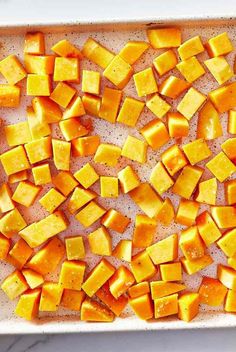 chopped up butter cubes in a baking dish on a marble counter top, ready to be cooked