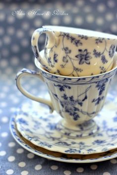 two cups and saucers are stacked on top of each other in blue and white