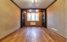 an empty room with hard wood floors and light fixtures on the wall, along with a radiator