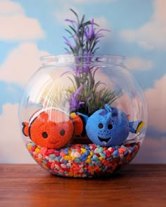 two stuffed animals are sitting in a fish bowl