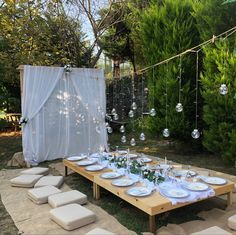 a table set up with plates and place settings for an outdoor dinner in the garden