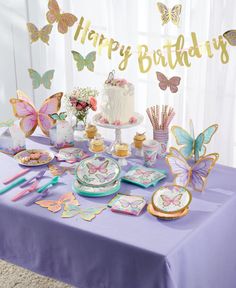 a purple table topped with plates and cake