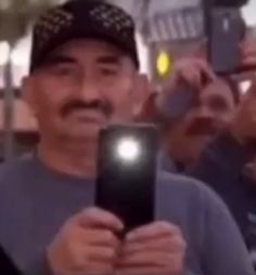 a man holding up a cell phone in front of his face