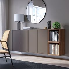 a living room with a chair, bookcase and round mirror