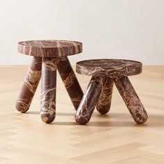 two wooden stools sitting on top of a hard wood floor next to each other