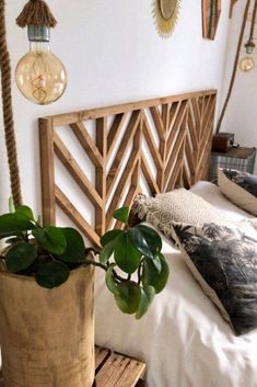 a bed with two planters on it and hanging lights above the headboard,