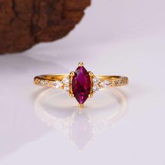 Our stunning vintage inspired ruby ring is made of 14K gold over 925 sterling silver and sealed to prevent gold fading backed by our lifetime warranty.   ✦ DETAILS ✦ ✧ Handcrafted  ✧ Stone Material: Ruby  ✧ Base Metal: Sterling Silver (925) ✧ Plating: 14K Gold ✧ Center Stone: Ruby ✧ Shape: Marquise ✧ Gem size: 6.0 x 8.0 mm ✧ Carat Weight: 1.3 ct. (approx.) ✧ Accented With Natural Quartz Diamonds ✧ PRE-ORDER: Items that are preorder only will ship within 10-15 business days.  You will receive an Latest Gold Ring Design For Women, Vintage Ruby Ring, Dainty Promise Ring, Ruby Ring Vintage, Gemstone Engagement Ring, Dainty Engagement Rings, Future Engagement Rings, Marquise Ring, Engagement Ring For Women