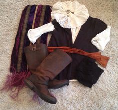 an assortment of clothing and accessories laid out on the floor, including boots, scarfs, and scarves