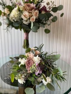 two vases filled with flowers sitting on top of a table