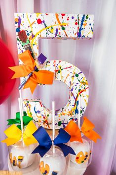 the number five cake pops are decorated with colorful paper streamers and bowknots