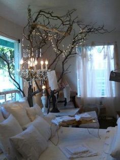 a bed with white pillows and a chandelier hanging from the ceiling