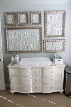 a baby crib in front of three framed letters