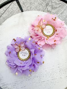 two pink and purple flowers sitting on top of a white table