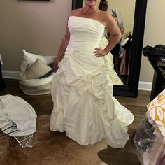 a woman standing in front of a mirror wearing a white dress with ruffles