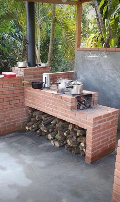 an outdoor bbq with wood stacked on it