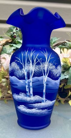 a blue vase sitting on top of a table