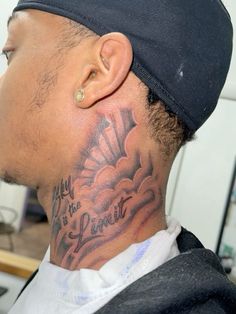 a man with a tattoo on his neck is looking to the side while wearing a black hat