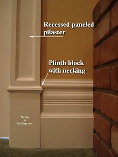 the corner of a brick wall with an exposed paneled plaster and plinth block with necking