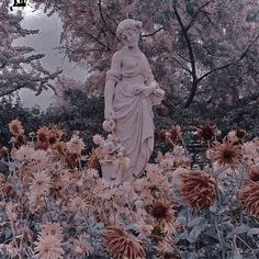 an image of a statue in the middle of flowers