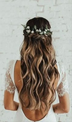 the back of a woman's head with long hair and flowers in her hair