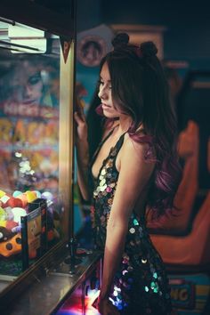 a woman standing in front of a vending machine with lots of gummy bears