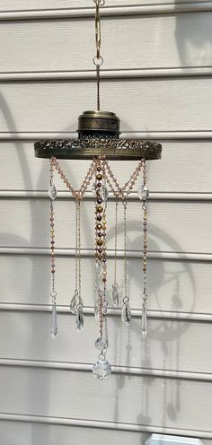 a chandelier hanging from the side of a house with beads and chains attached to it