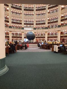 the inside of a library with people working on laptops and reading books in it