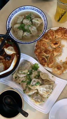 several plates of food on a table with soup, dumplings and other foods in bowls