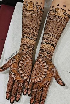 two hands with henna designs on them