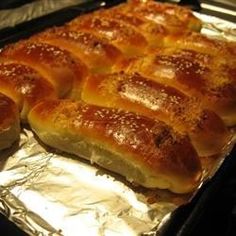 hotdogs wrapped in bread sitting on top of tin foil