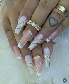 a woman's hands with white and gold nails