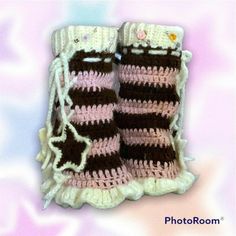 a pair of crocheted baby booties on top of a pink and white blanket