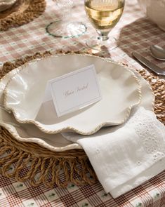 a table setting with place cards and napkins on it, along with wine glasses