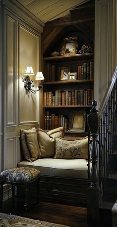 a living room filled with lots of books on top of a book shelf next to a stair case