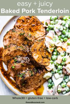 a white plate topped with meat, peas and salad next to a fork on a table