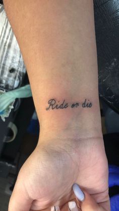 a woman's wrist tattoo with the words ride or die written in cursive font