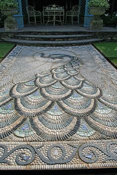 an intricately designed mosaic on the ground in front of a gazebo with tables and chairs