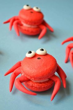 red macaroons with googly eyes on them sitting in front of each other